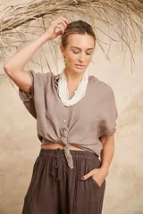 Camisa marrón de lino con cuello mao, manga corta y cierre frontal con botones.