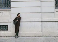 Vestido midi de punto color marrón, con escote bote caído, manga larga y tajo lateral en la falda.