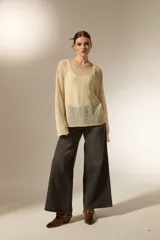 Sweater de tejido de punto calado con lurex, cuello redondo a la base y mangas largas con diseño holgado.