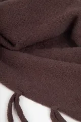 Bufanda triangular tejida en color negro, con detalle de flecos en todo el borde. Diseño versátil que permite su uso como bufanda o poncho.