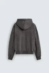 Sudadera con capucha y cierre de cremallera frontal, color negro con efecto lavado (acid wash). Presenta un corte relajado (relaxed fit) y bolsillos tipo canguro frontales.