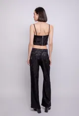 Pantalón palazzo negro con estampado abstracto a tono, de tela fluida, con botón y cierre de plástico.