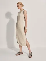 Vestido midi tejido color crema con ribete negro en cuello, sisas y ruedo. Presenta aberturas laterales en el ruedo.