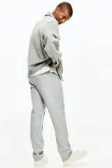 Pantalón tipo jogger de punto de peso medio con pliegue frontal cosido, cintura elástica con cordón de ajuste, bolsillos laterales y bolsillo trasero insertado.