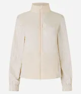 Campera rompevientos deportiva de mujer, marca Get Over, color beige con sutiles rayas verticales, cuello alto, cierre frontal con cremallera y puños ajustados.