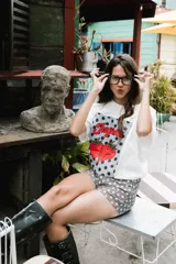 Remerón blanco de algodón con estampado frontal de dos frutillas rojas y la palabra "Jugosa" en rojo, sobre un fondo de lunares negros.