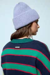 Sweater de punto con diseño de franjas horizontales multicolores en tonos verde, azul marino, rojo y celeste. Presenta cuello redondo y mangas largas con puños acanalados.