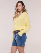 Cardigan blanco de punto liviano y texturado, de corte holgado y diseño casual. Cuenta con escote en V pronunciado, abotonadura frontal, mangas largas con hombros caídos y bolsillos delanteros tipo parche.