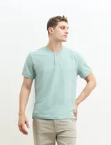 Remera tipo henley de manga corta, color beige, con cuello redondo y cartera de botones frontal.