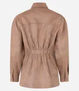 Campera estilo safari o sobrecamisa de mujer, color marrón camel, confeccionada en tejido que simula gamuza o cuero sintético. Presenta cuello camisa, cierre frontal de botones a presión, y cuatro bolsillos frontales con tapa (dos en el pecho y dos a la altura de la cadera). Tiene costuras visibles que definen el diseño.