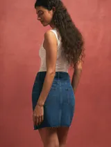 Minifalda de denim azul oscuro, de corte recto con diseño clásico de cinco bolsillos y costuras visibles en contraste.