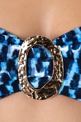 Top de bikini bandeau con estampado abstracto en tonos azules y negros. Presenta una hebilla dorada en el centro, breteles removibles y ajustables, y detalle de fruncido lateral.