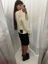 Buzo tejido de lana merino color marfil, con diseño holgado, mangas largas y detalle de una oveja negra bordada en la parte inferior trasera.