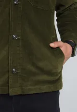 Sobrecamisa negra de pana con cuello clásico, cierre frontal con botones, dos bolsillos de parche con solapa en el pecho y puños abotonados.