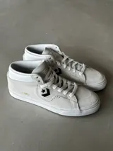 Championes de skate Converse Louie Lopez Pro Mid, color blanco hueso, confeccionados en gamuza con detalles perforados y logo de estrella en negro.