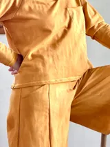 Conjunto de dos piezas compuesto por un buzo de cuello en V con bolsillo frontal y un pantalón tipo palazzo de corte evasé y pierna ancha. Confeccionado en tejido rústico de algodón con efecto batik.