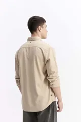 Camisa de manga larga color azul marino con textura, cuenta con cuello clásico, cierre frontal con botones y un bolsillo en el pecho.