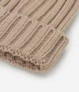 Gorro de punto acanalado color tostado, con diseño clásico de vuelta y pompón de pelo sintético en la parte superior.