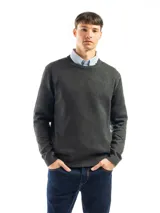 Buzo de punto liso color negro, con cuello redondo y puños y ruedo acanalados. Se lleva sobre una camisa celeste de vestir.