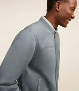 Chaqueta bomber azul marino lisa, con cierre frontal, cuello redondo y bolsillos laterales.