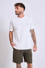 Remera azul marino de algodón con cuello redondo y manga corta. Presenta un pequeño bordado de un pájaro en el área del pecho.