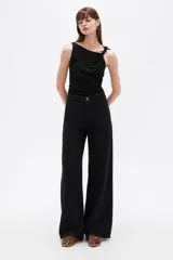 Pantalón jean negro de tiro alto y corte ancho.