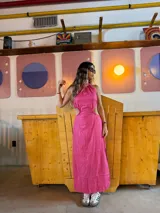 Vestido largo fucsia con espalda descubierta y aberturas laterales en la cintura.