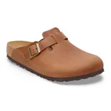 Zueco tipo mule de cuero color cognac, con diseño cerrado en la parte frontal y ajuste mediante una correa con hebilla metálica lateral. Cuenta con plantilla anatómica de corcho y suela de goma antideslizante.