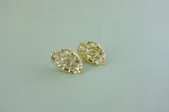 Par de aros colgantes de bronce y alpaca con diseño abstracto calado.