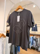 Remera de manga corta Ciara, color gris oscuro, con escote redondo y diseño estampado de flor en trazo continuo blanco.