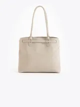 Bolso tipo tote color gris, confeccionado en cuero vacuno, con asas largas para hombro, detalles metálicos personalizados, cierre central y llavero con candado y llave colgante.