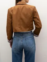 Blazer crop color marrón, marca Dictionary. Cuello con solapa, manga larga y forro interno estampado a rayas.