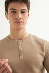 Sweater de punto color beige, de acrílico, con cuello redondo y manga larga.