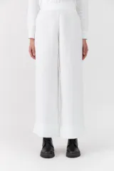 Pantalón blanco de lino, corte recto y amplio, con tiro alto y botamanga ancha.
