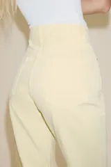 Jeans de mujer, tiro alto, color azul medio con efecto desgastado (lavado claro en muslos y oscuro en bordes). Corte recto y ancho (mom fit) con cinco bolsillos y cierre frontal de botón y cremallera.