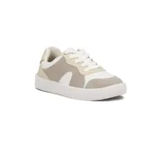 Championes deportivos de mujer, color blanco y beige, con detalles en color crema. Presentan un diseño de paneles superpuestos y suela gruesa con textura.
