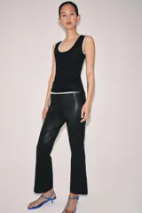 Pantalón de tiro medio confeccionado en piel 100%, con diseño de corte flare o evasé en el bajo y cierre de cremallera oculta en la costura lateral.