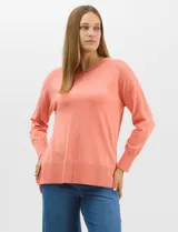 Buzo de tejido fino color amarillo, con cuello redondo, manga larga con puños acanalados y pespunte central vertical en el frente y la espalda. Presenta un ruedo ancho acanalado con tajos laterales.