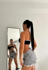 Body negro con aberturas laterales y ribete blanco, de breteles finos y corte irregular.