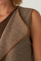 Chaleco color beige con textura tipo espiga, corte holgado y solapa cruzada.