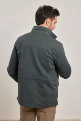 Campera verde militar de algodón y elastano, con cierre frontal de botones y cremallera, cuatro bolsillos delanteros con solapa y cordón ajustable en la cintura. Forro interior de viyela de algodón a cuadros.