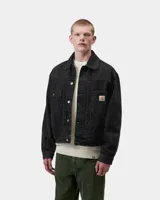 Campera de denim negra con estampa animal print sutil, corte clásico, bolsillos frontales con solapa y cierre de botones metálicos. Incluye la etiqueta con el logo de Carhartt en el bolsillo izquierdo.