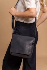 Bandolera de diseño simple con tapa frontal, confeccionada en material símil cuero. Cuenta con correa ajustable, división interna y bolsillos internos para mayor organización.