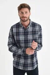 Camisa de manga larga con estampado de cuadros en tonos azul, gris y líneas finas en color naranja. Presenta cuello con botones, cierre frontal abotonado y un bolsillo en el pecho.