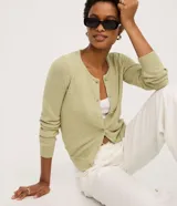 Cardigan de punto color verde claro, de manga larga y corte regular, con escote redondo y cierre frontal de botones.