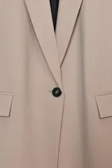 Blazer de cuello solapa y manga larga, con bolsillos delanteros con solapa y cierre frontal de un botón. Presenta un diseño estructurado con forro interior.