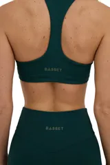 Top deportivo verde inglés con escote medio redondeado y espalda deportiva.