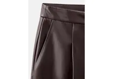 Pantalón de cuero sintético color marrón, de corte recto y tiro medio con pinzas en la cintura.
