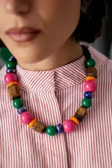 Collar corto de cuentas grandes con diseño multicolor, compuesto por una mezcla de piedras ojo de tigre, cuentas de cerámica, cristales checos y acrílico. Incluye cadena de ajuste con cierre de gancho.