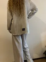 Camisa plateada plisada de manga larga con cuello camisero y cierre con botones.